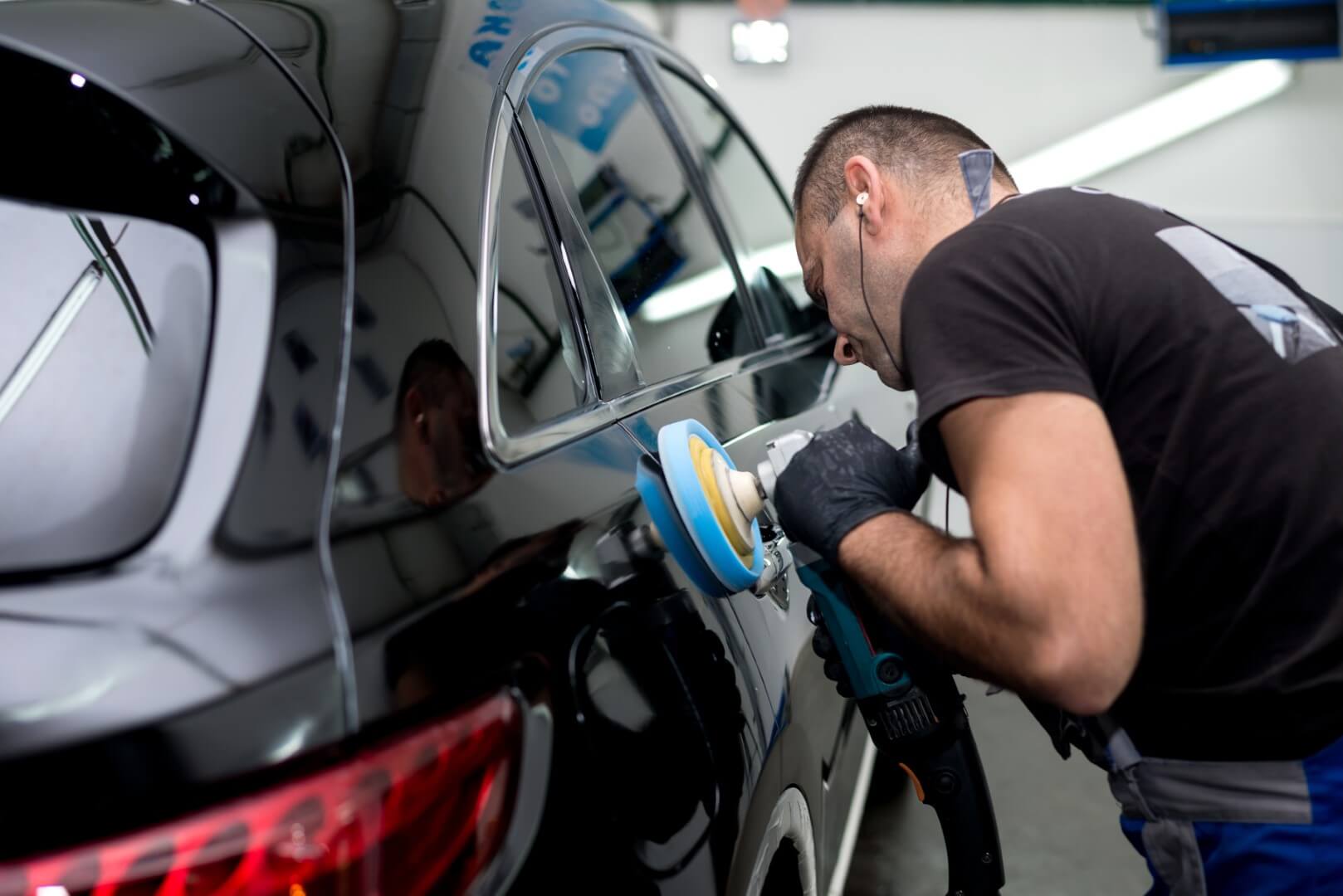 Car detailing expert from Aurora waxing a car.